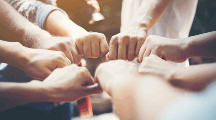 Team of professionals collaborating around a table, representing acqui-hiring, where a company is acquired for its talent rather than its product.